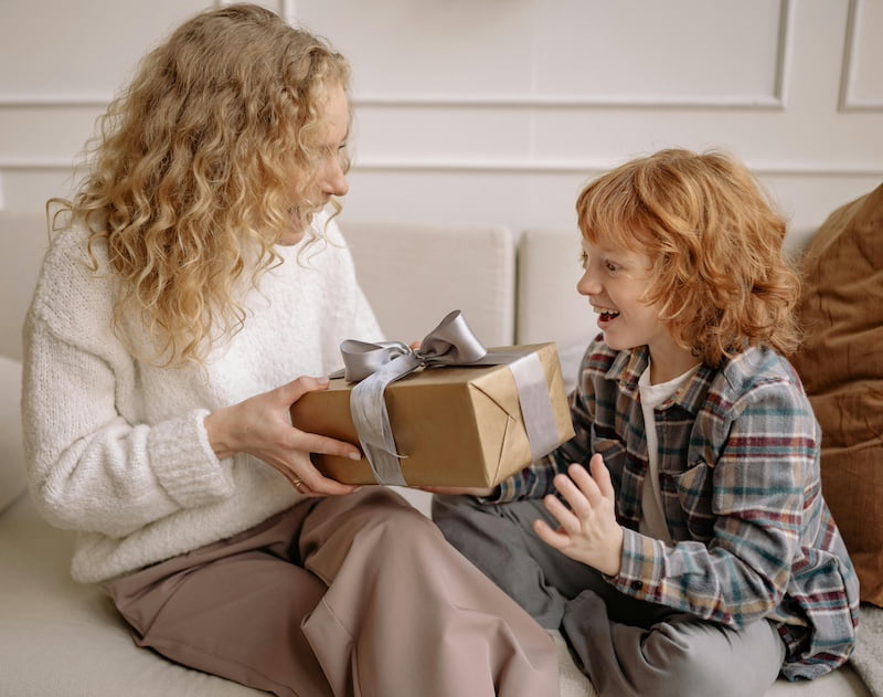 Enfant qui offre un cadeau à sa mère pour la fête des mères